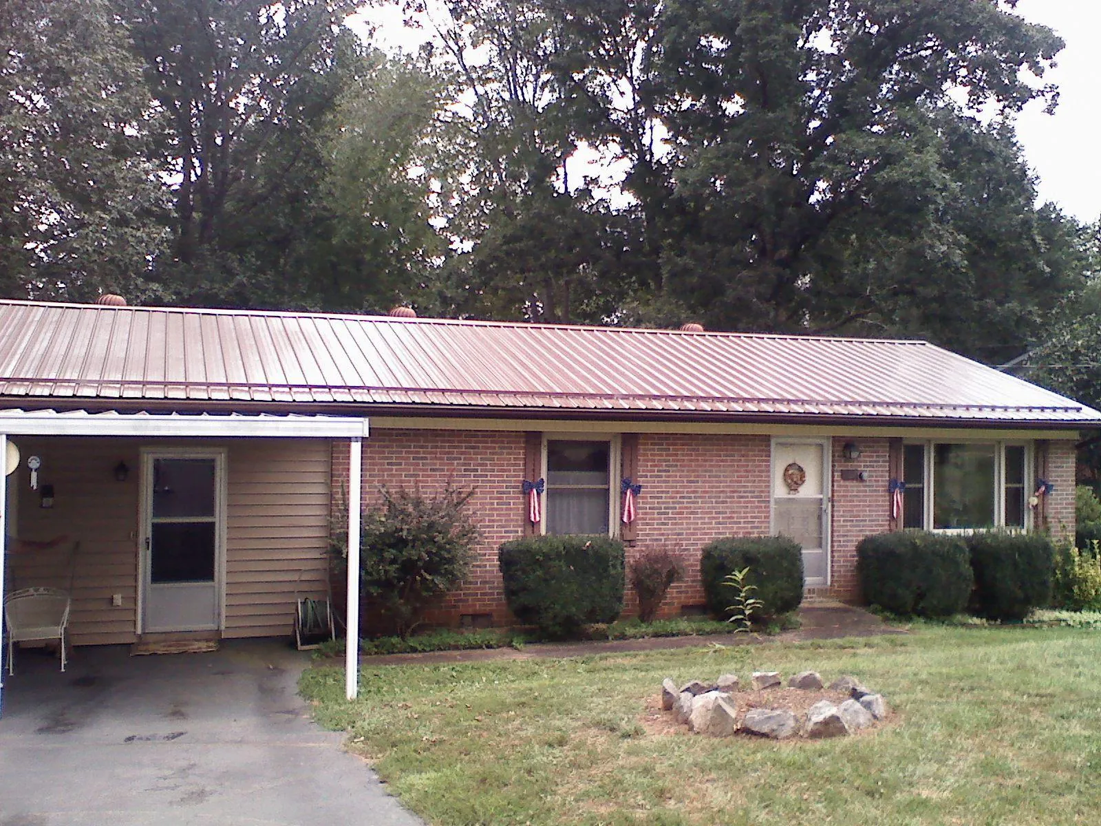 Bronze metal roof and carport on a brick ranch home — Roof Repair work by our crew in Gresham